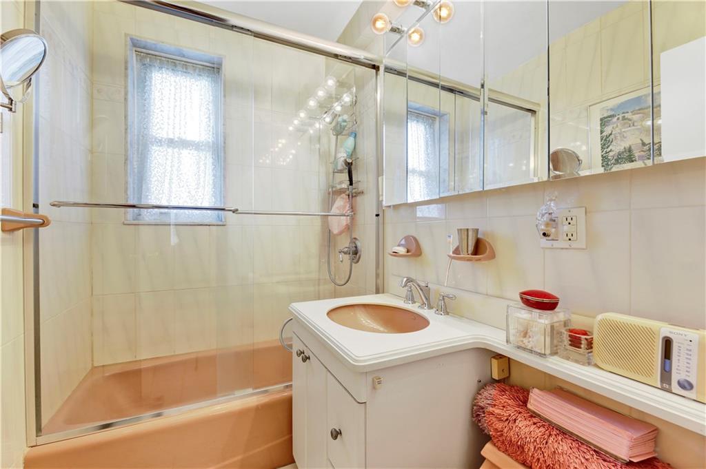 131 74th Street, Unit 6J Brooklyn, NY 11209 - Photo 19 of 21 a bathroom with a sink a bath tub and a shower