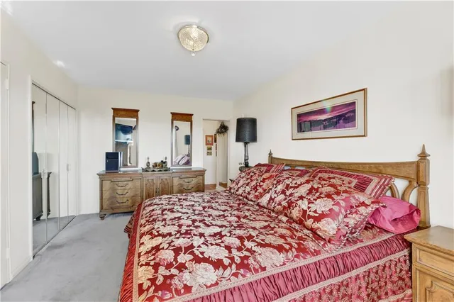 a bed sitting in a bedroom next to a window with a dresser