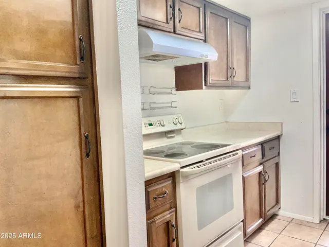 a view of a kitchen with white cabinets and a stove