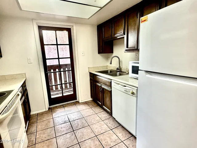a kitchen with a sink a stove top oven and a refrigerator