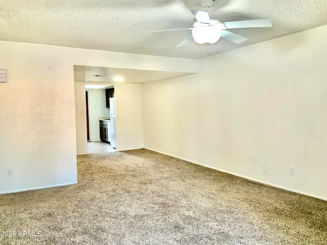 an empty room with kitchen view