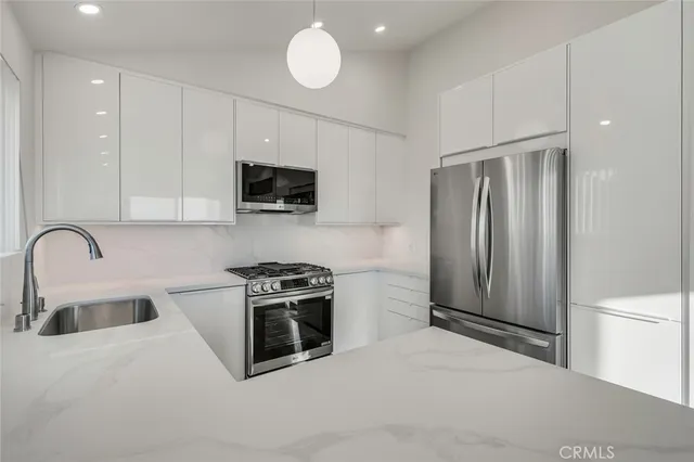 a view of a hallway with wooden floor and a bathroom