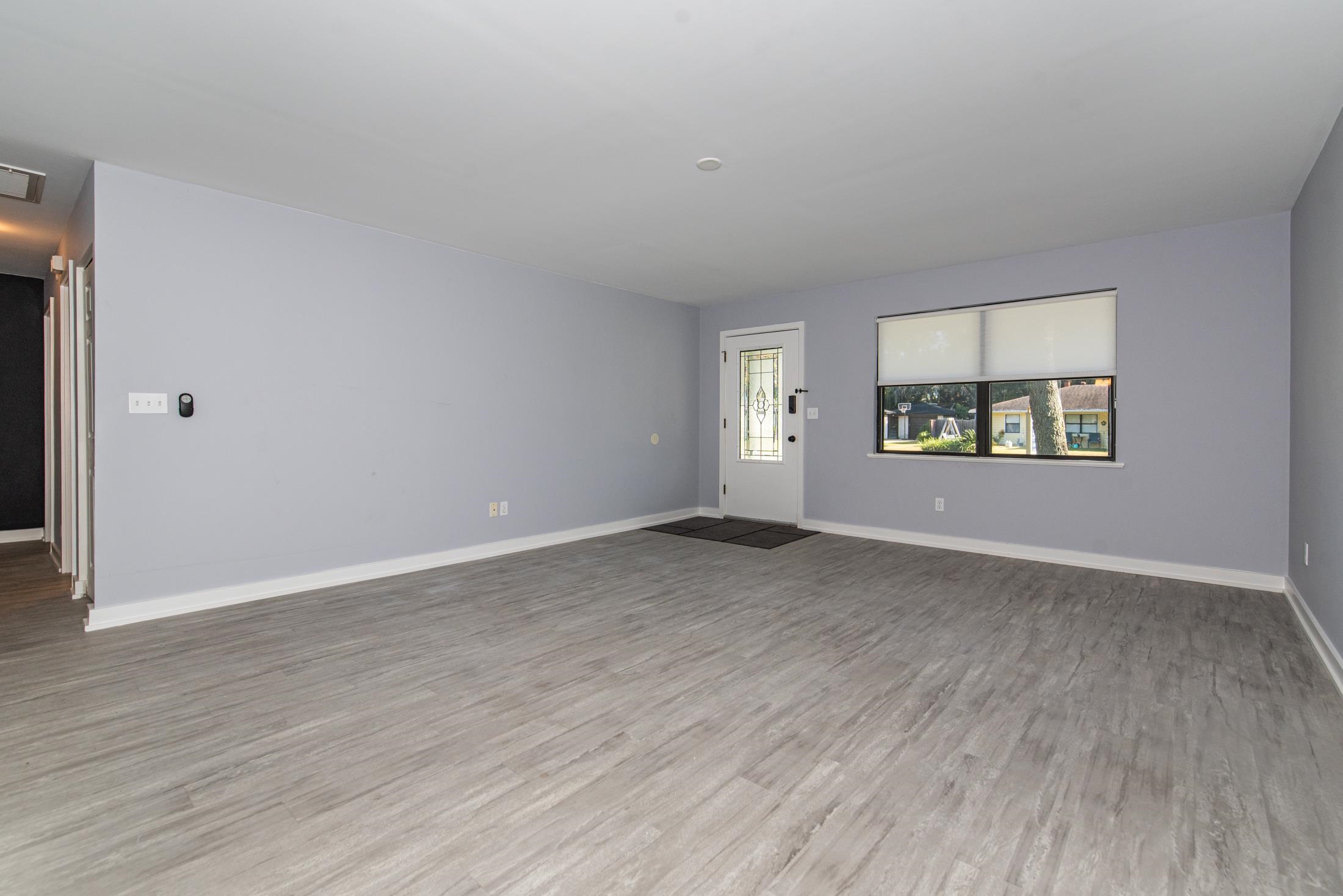 140 Orchis Road St. Augustine, FL 32086 - Photo 4 of 41 an empty room with wooden floor and windows
