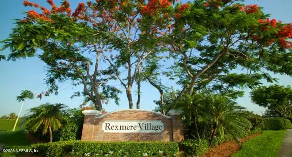 a sign that is sitting in front of a tree