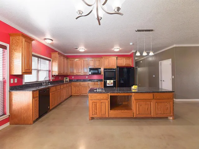 a kitchen with stainless steel appliances kitchen island granite countertop a sink and cabinets
