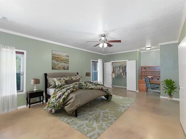 a spacious bedroom with a bed and a chandelier