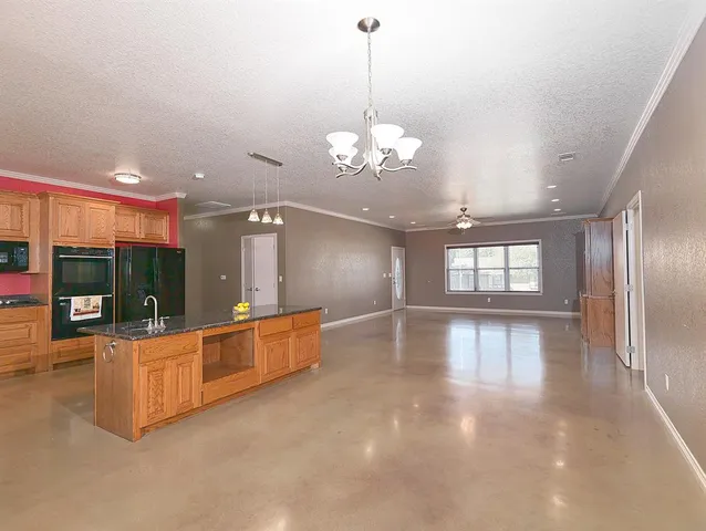 a view of a room with lots of wooden furniture and a chandelier
