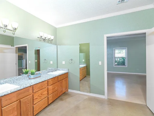 a spacious bathroom with a granite countertop sink a mirror and a shower