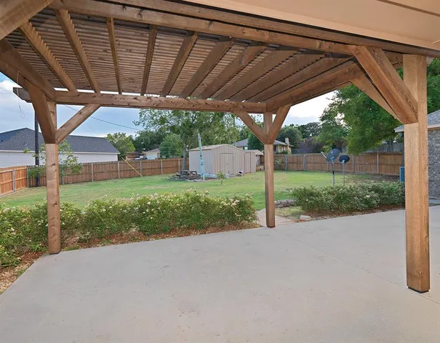 a view of a backyard with wooden fence and a big yard