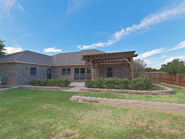 a view of a big house with a big yard and potted plants