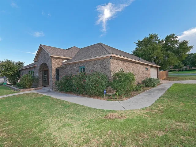 a view of a house with a yard and potted plants