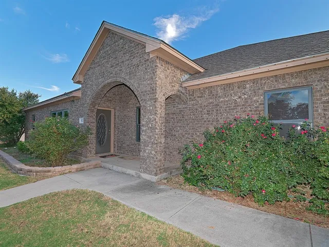 a view of a stone house with potted plants