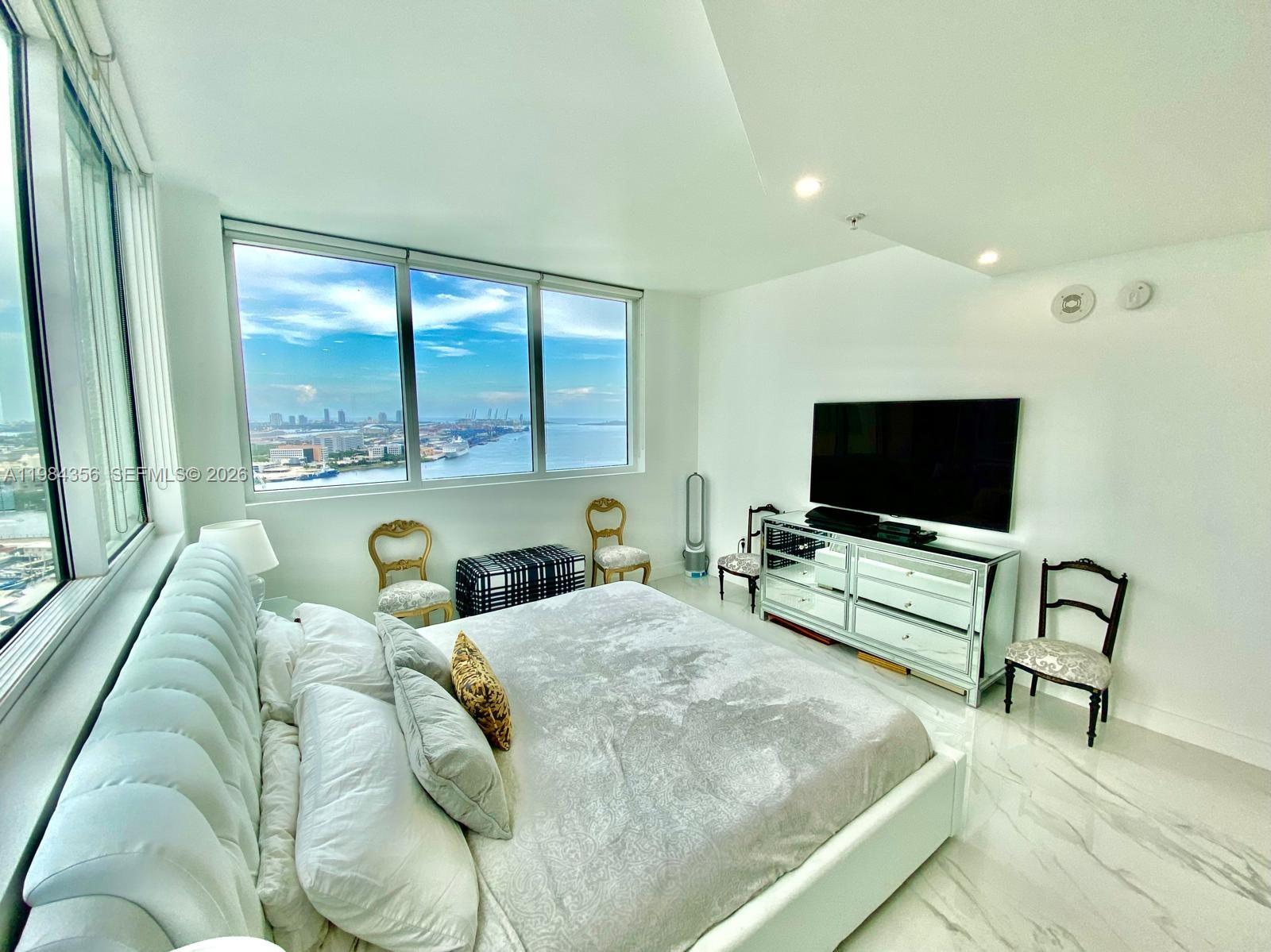 253 Northeast 2nd Street, Unit 2703 Miami, FL 33132 - Photo 13 of 33 a living room with furniture and a flat screen tv