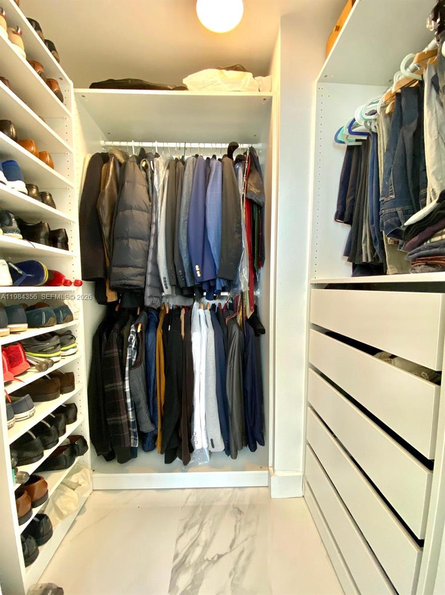 253 Northeast 2nd Street, Unit 2703 Miami, FL 33132 - Photo 18 of 33 a view of walk in closet with clothes and shoes