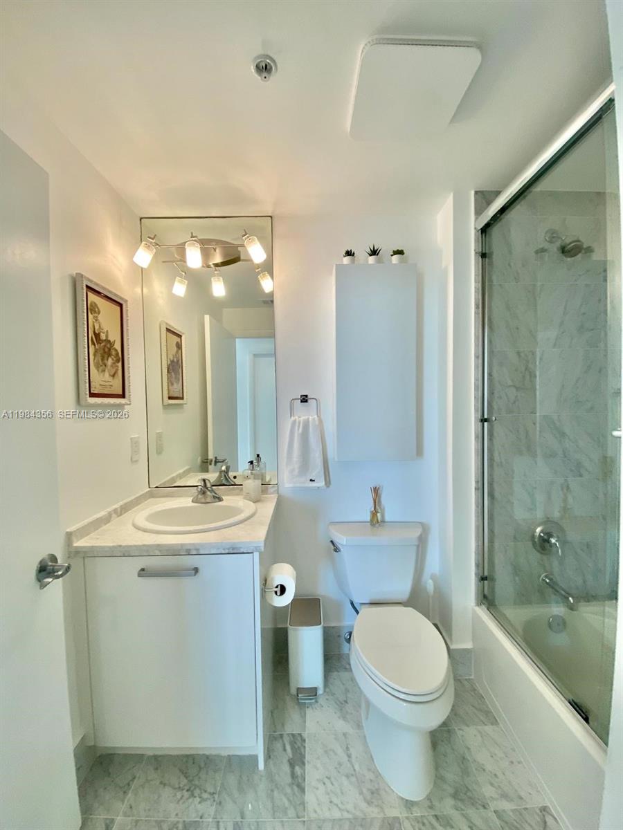 253 Northeast 2nd Street, Unit 2703 Miami, FL 33132 - Photo 22 of 33 a bathroom with a sink a toilet and shower
