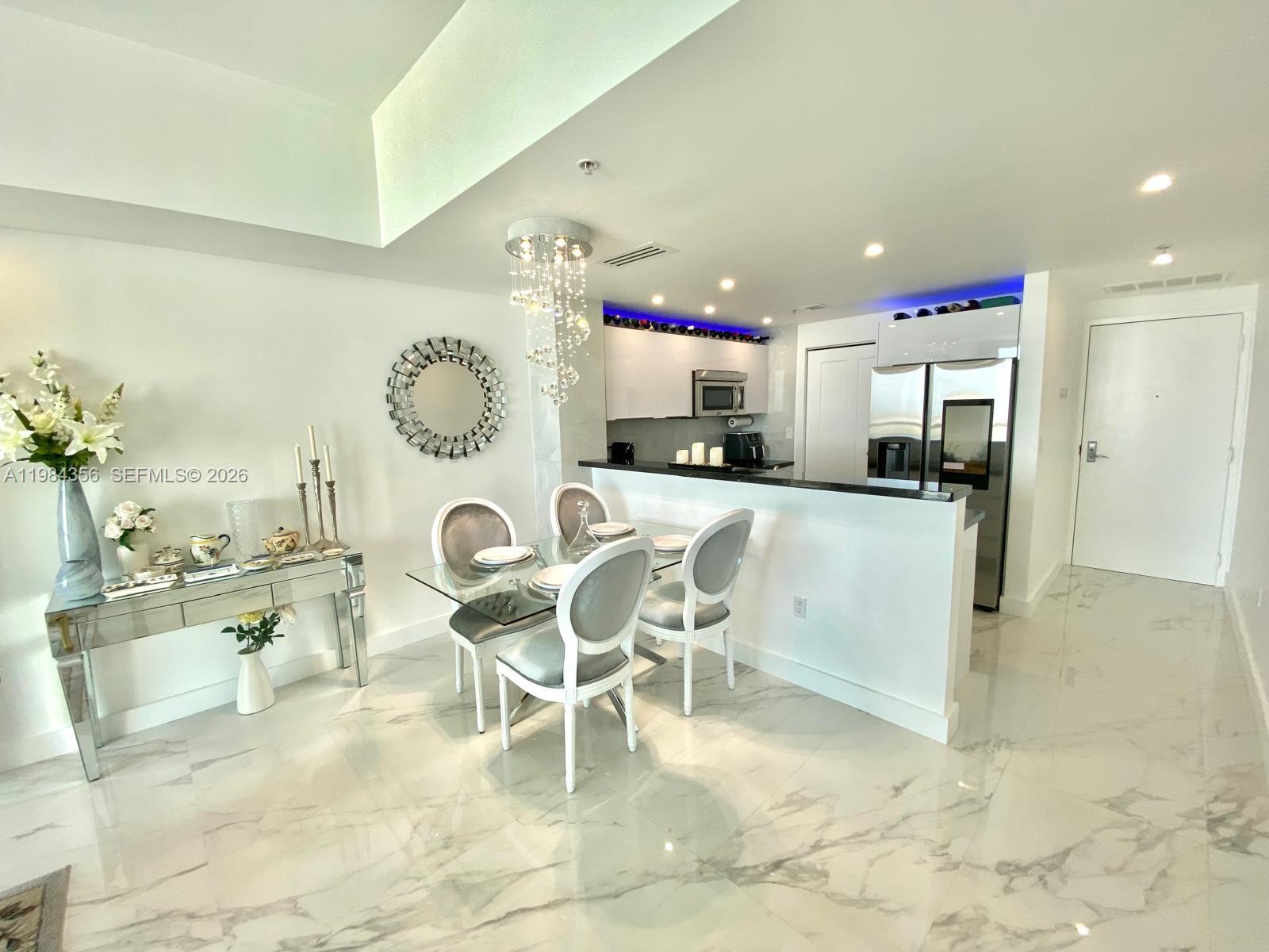 253 Northeast 2nd Street, Unit 2703 Miami, FL 33132 - Photo 5 of 33 a large kitchen with a table and chairs