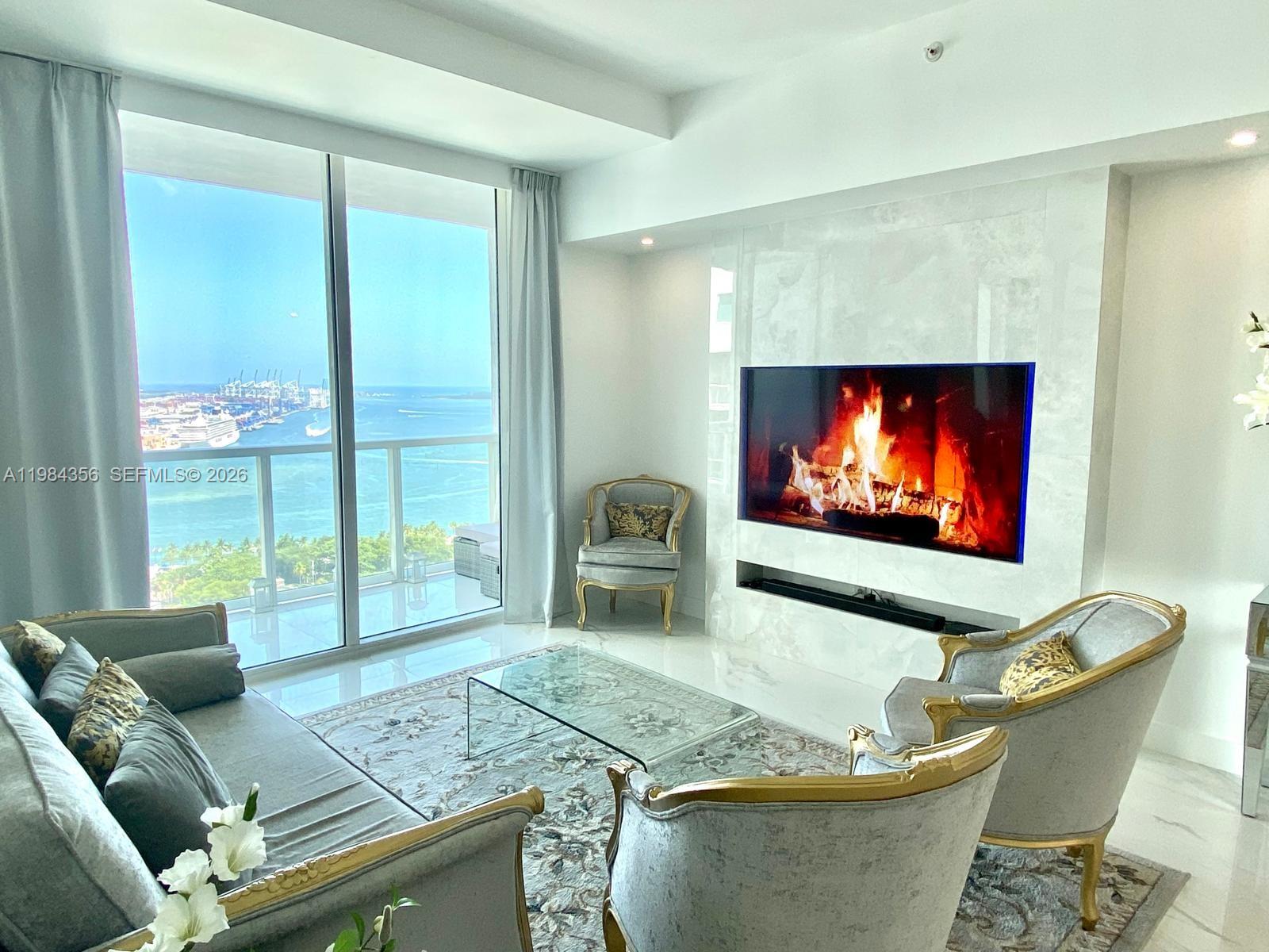 253 Northeast 2nd Street, Unit 2703 Miami, FL 33132 - Photo 6 of 33 a living room with furniture and a flat screen tv