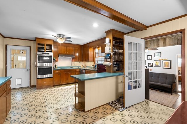 a kitchen with stainless steel appliances kitchen island granite countertop a refrigerator and a sink