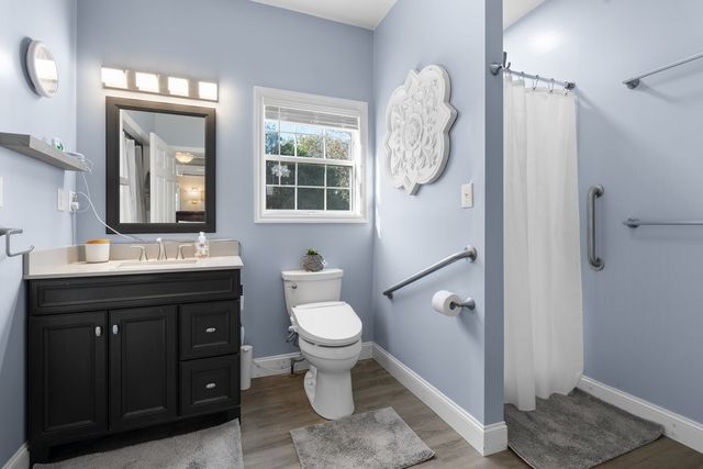 a bathroom with a toilet a sink and mirror