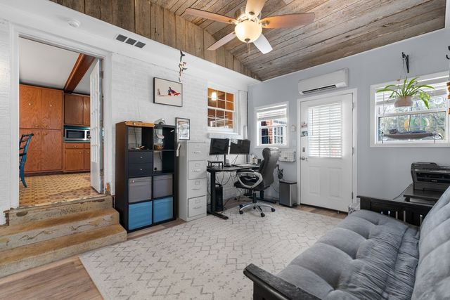 a view of a livingroom with workspace and a window