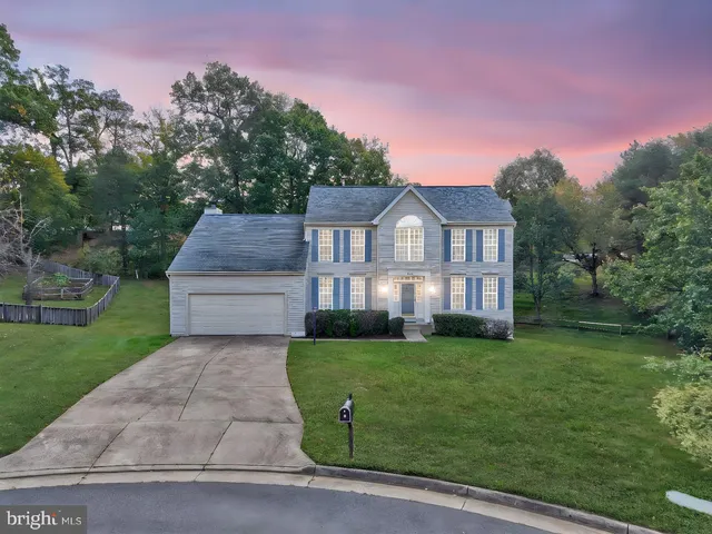 a view of a big house with a big yard and large trees