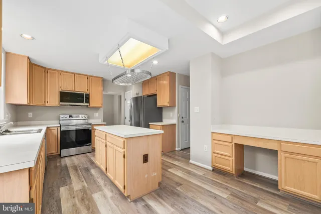 a kitchen with stainless steel appliances a refrigerator a sink a stove and a refrigerator