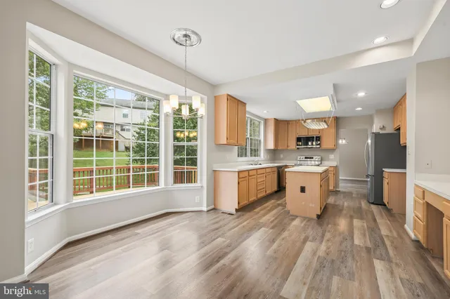 an empty room with windows fireplace and wooden floor