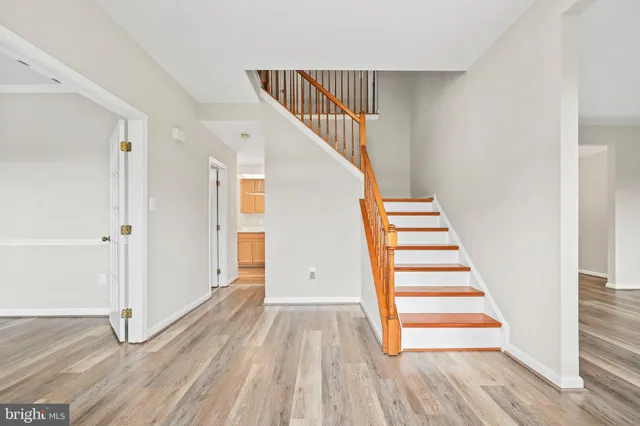 a view of an empty room with wooden floor and windows