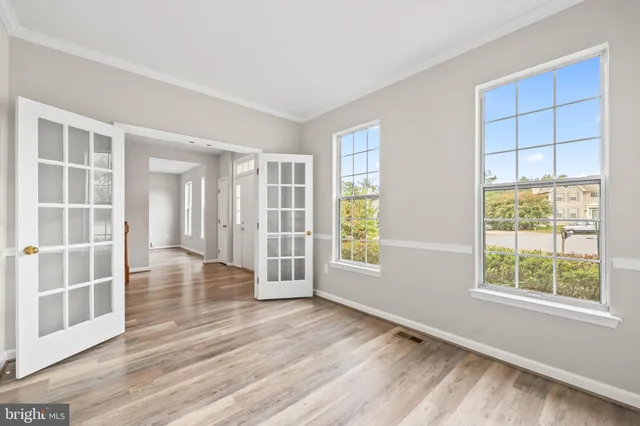 a view of a hallway with wooden floor and windows