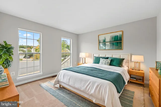 a living room with a bed furniture and next to a window