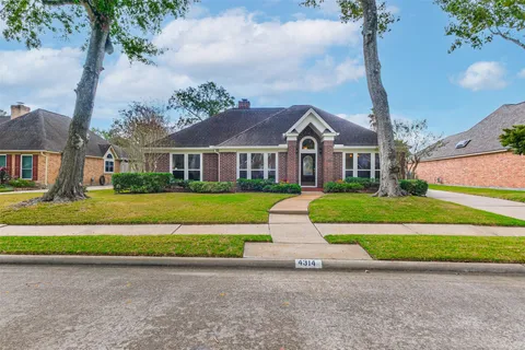a front view of a house with a garden and yard