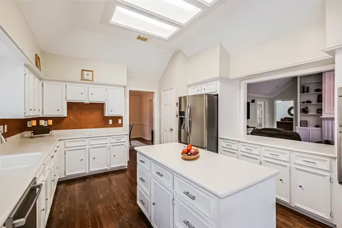 a kitchen with refrigerator cabinets and wooden floor