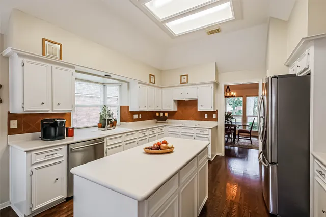a kitchen with refrigerator cabinets and wooden floor