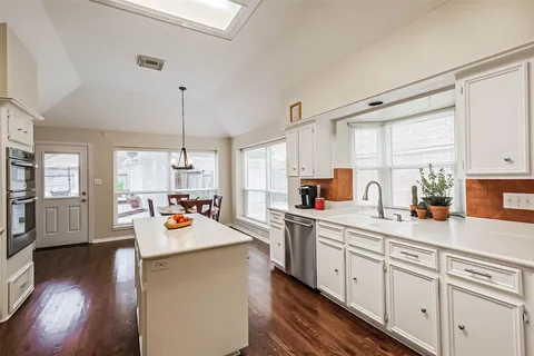 a kitchen with a sink a stove and cabinets