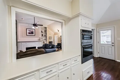 a kitchen with cabinets and wooden floor