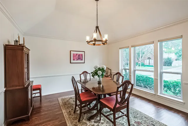 a dining room with furniture a chandelier and wooden floor