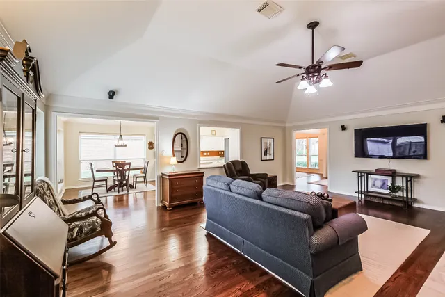 a living room with furniture and a flat screen tv with wooden floor