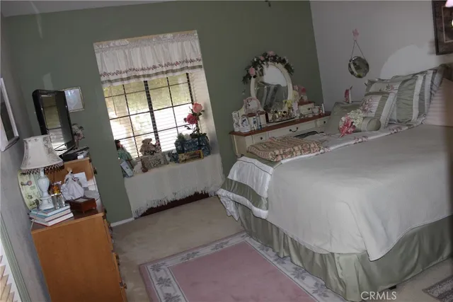 a bedroom with a bed a mirror and dresser