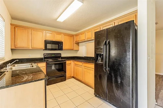 a kitchen with granite countertop a refrigerator and a sink
