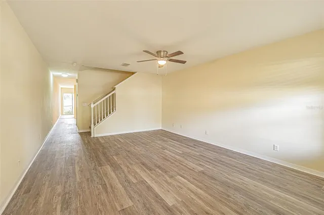 a view of an empty room with wooden floor