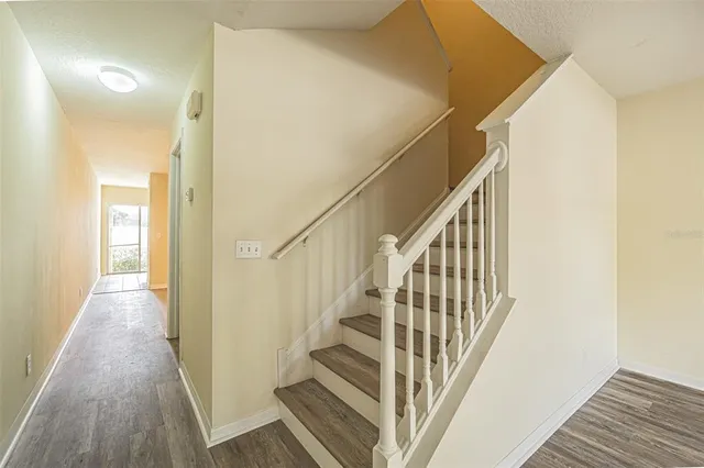 a view of staircase with wooden floor and white walls