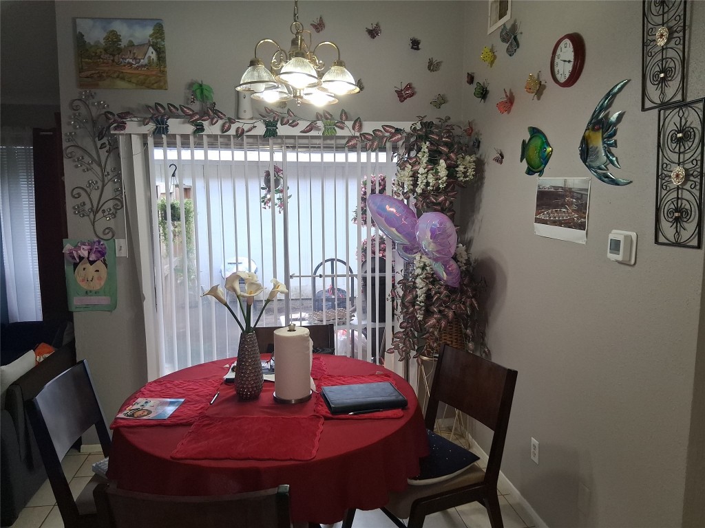 23347 Pebworth Place Spring, TX 77373 - Photo 5 of 10 A cozy dining area featuring a warm, inviting atmosphere with decorative wall accents and ample natural light from the sliding glass doors. Perfect for intimate gatherings or family meals.