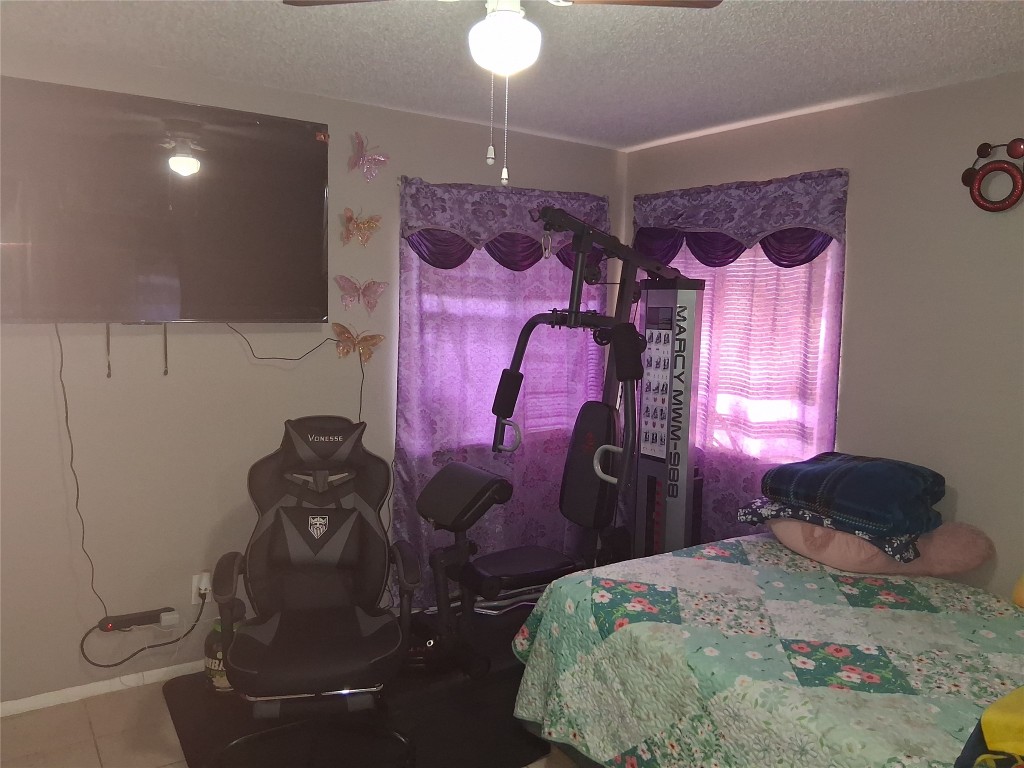 23347 Pebworth Place Spring, TX 77373 - Photo 6 of 10 Cozy main bedroom featuring a large TV, exercise equipment, and abundant natural light.