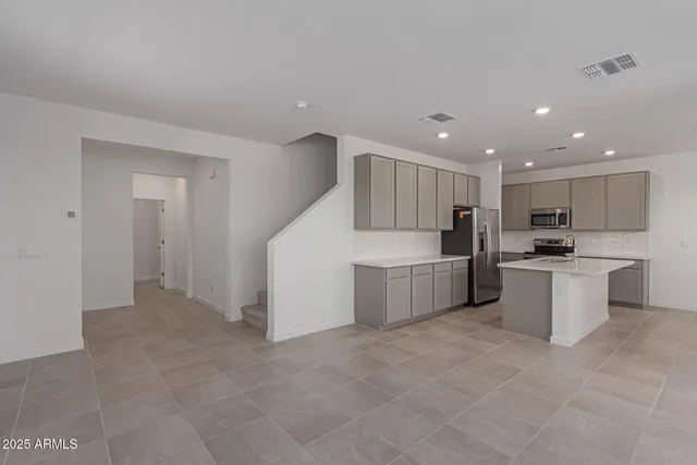 a large kitchen with a large counter top stainless steel appliances and cabinets