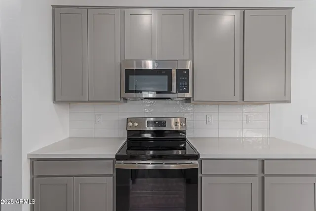 a kitchen with microwave cabinets and stove top oven