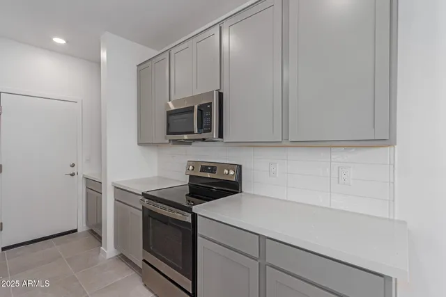 a kitchen with granite countertop white cabinets stainless steel appliances and a sink