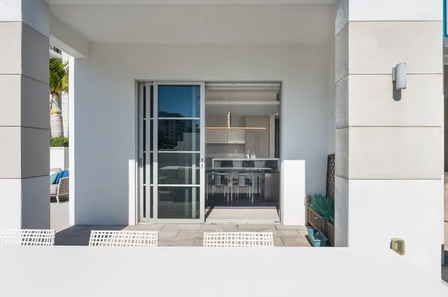 a view of a patio with couches table and chairs and potted plants