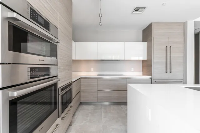a kitchen with stainless steel appliances a stove microwave and sink