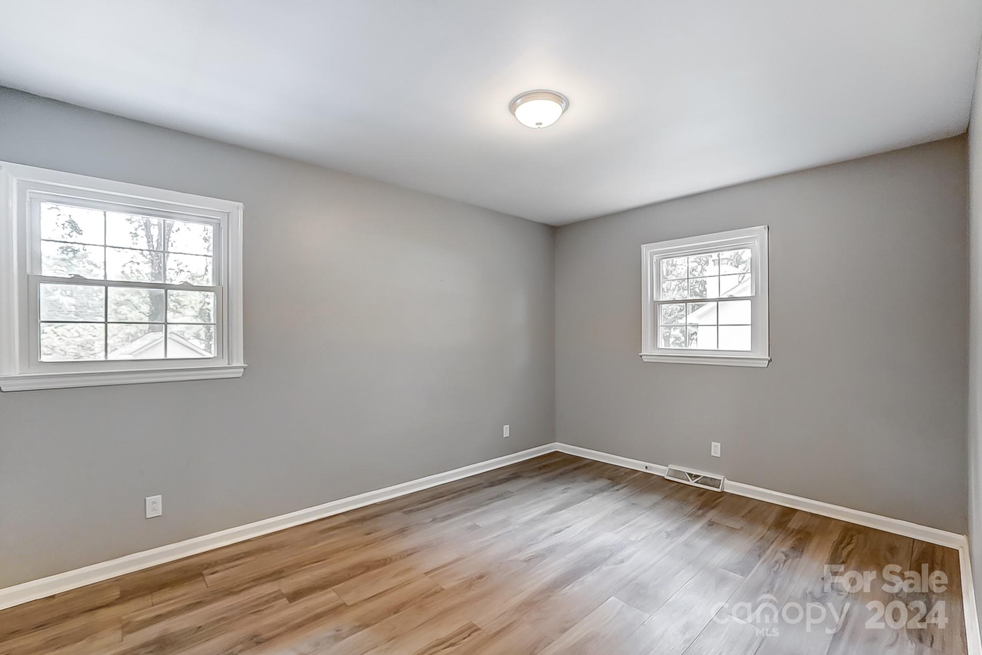 3218 Valley Grove Road Charlotte, NC 28227 - Photo 12 of 23 an empty room with wooden floor and windows