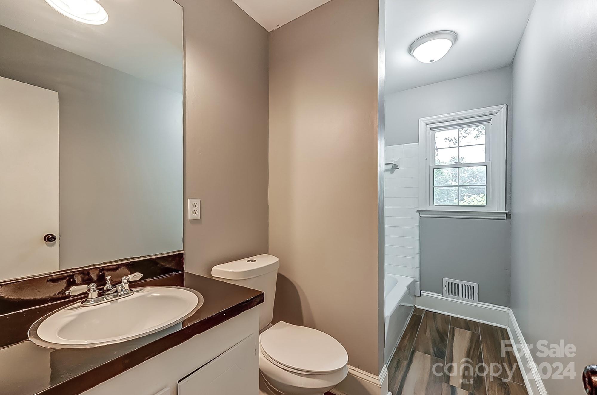 3218 Valley Grove Road Charlotte, NC 28227 - Photo 17 of 23 a bathroom with a granite countertop sink toilet a mirror and a sink